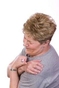 flu like symptoms, woman holding sore shoulders